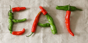 The word EAT is spelled out with red and green peppers.