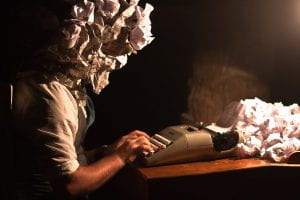 creative image of writer at typewriter, head made of wadded up paper