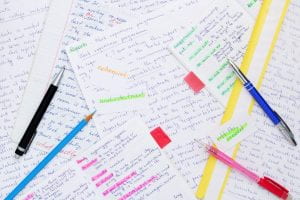 image of various papers and pens, with notes from writing