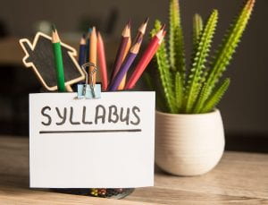 Photo of a pencil cup with a note reading "syllabus" clipped to it.