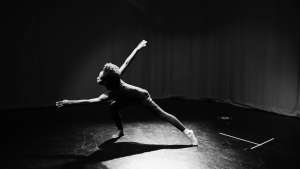 A woman dances in a spotlight
