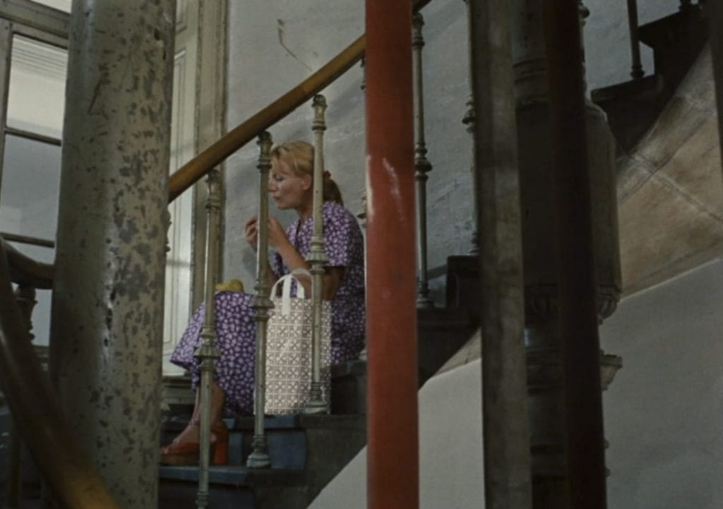 By the end of the film, Yolanda, a new coworker from Yugoslavia, has literally taken Emmi's place, by replacing her position alone on the stairs shown earlier in the film.
