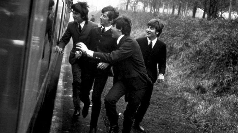 The Beatles harassing a man while running alongside a train.