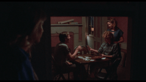 Through the window, we see Connie's family playing cards