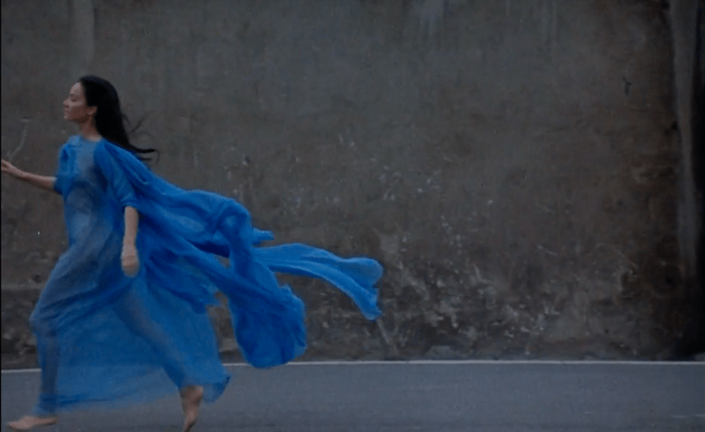 Oja Kodar runs in blue sheer fabric