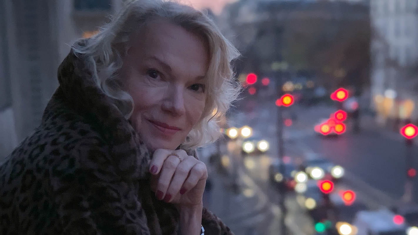 Brigitte Lahaie on a balcony overlooking a city street in One Last Time (2020)