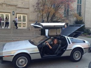 IU Cinema Associate Director Brittany D. Friesner sits in a DeLorean parked outside of the Cinema on Back to the Future Day, October 21, 2015