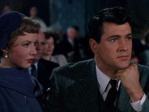 Rock Hudson and Piper Laurie talking in a movie theater