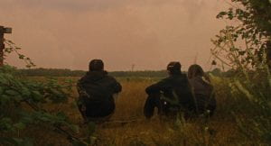 A group of people sit in a field