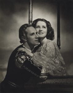 A man and woman in period garb in a black and white portrait