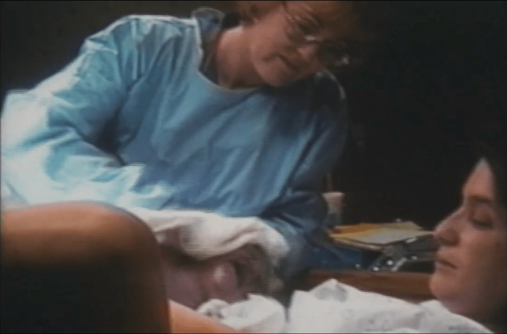 Video footage of a doctor or midwife handing Lynne her newly birthed baby