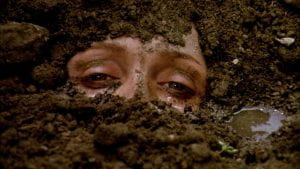 Close-up of a person's face that is covered in dirt except for their eyes