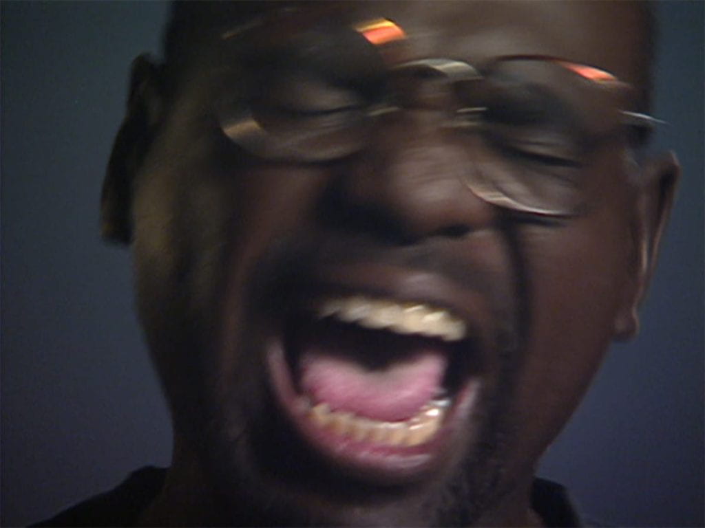 Close-up of a man in glasses screaming