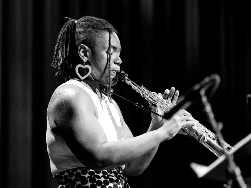 Aja plays the saxophone onstage