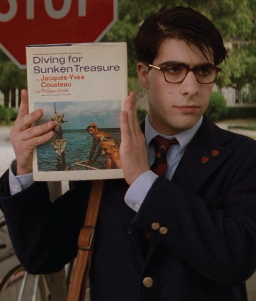 Max Fischer holds up the book Diving for Sunken Treasure