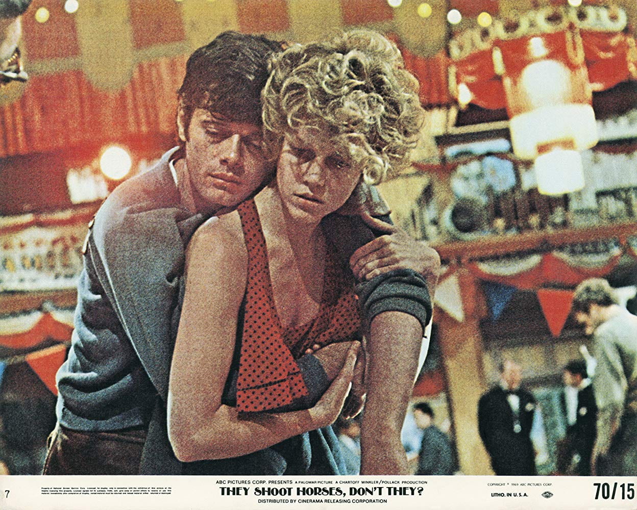 A lobby card showing an exhausted man clinging to a woman's back as she props him up