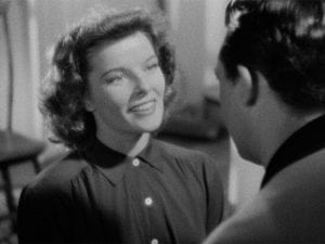Close-up of Katharine Hepburn as she smiles and looks at Cary Grant