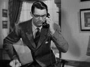 Cary Grant talking into a telephone while holding a bone in his other hand