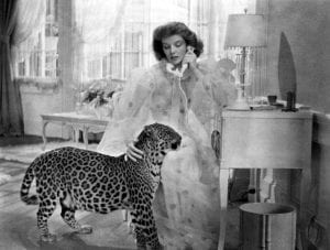Katharine Hepburn talks on the phone while petting Baby the leopard