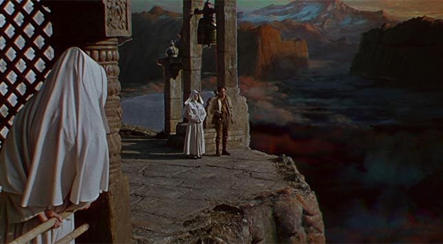 Deborah Kerr and Peter Finch stand on the precipice of a mountain on the grounds of a convent