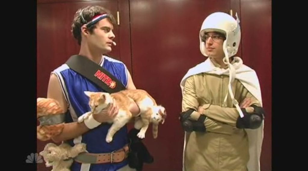 Bill Hader holds a cat and stands next to Andy Samberg