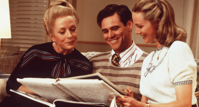 Holland Taylor, Jim Carrey, and Laura Linney sit together and look through a photo album