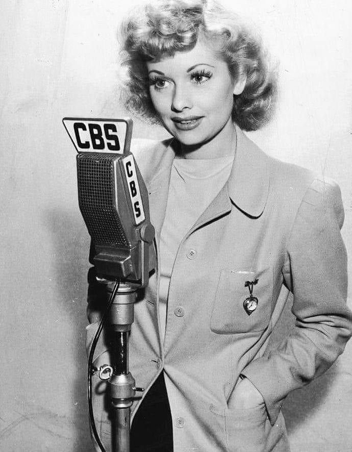 Lucille Ball poses with a CBS Radio microphone