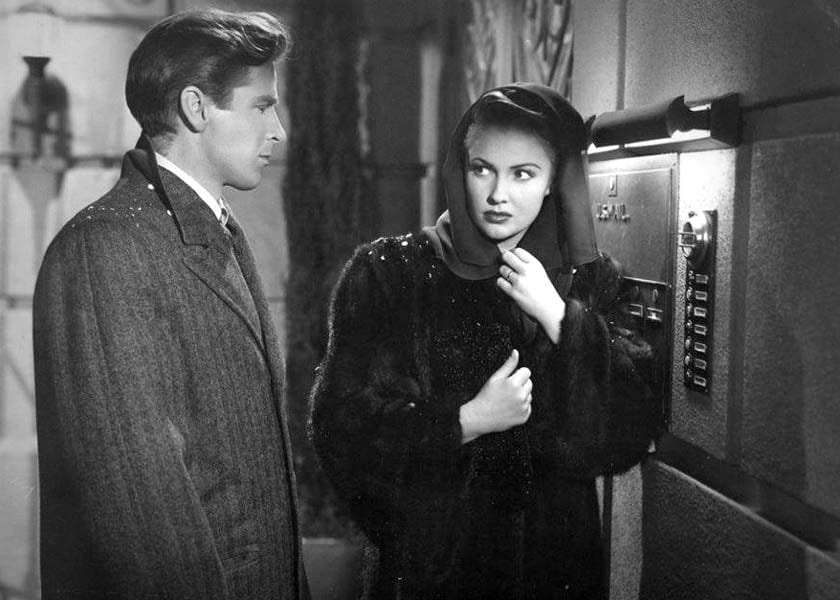 Richard Basehart and Joan Leslie stand outside of an apartment building