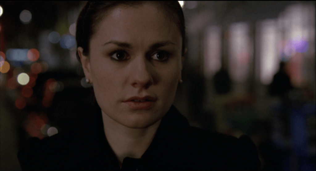Close-up of Anna Paquin with colorful lights in the background