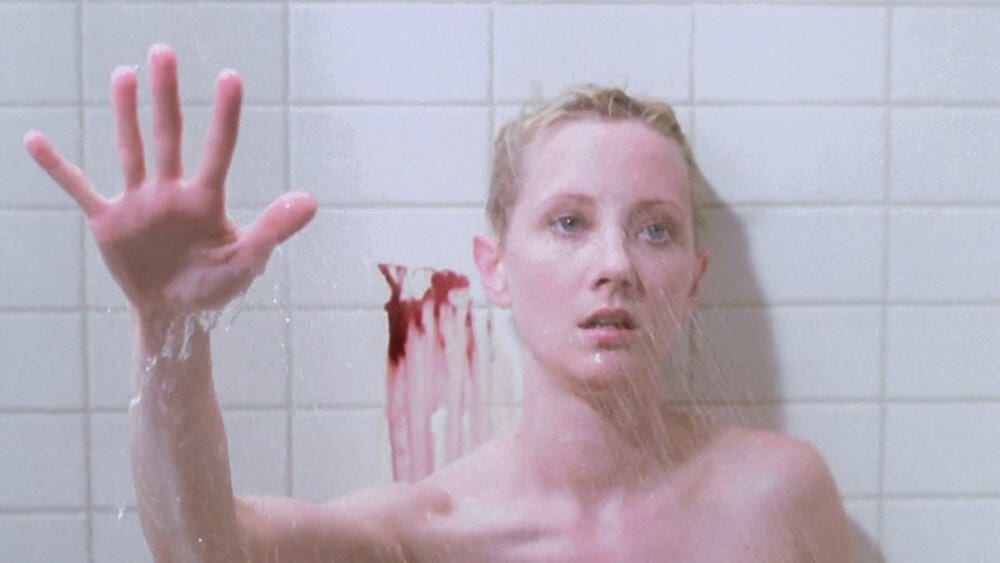 A woman in a bloody shower reaches her hand out