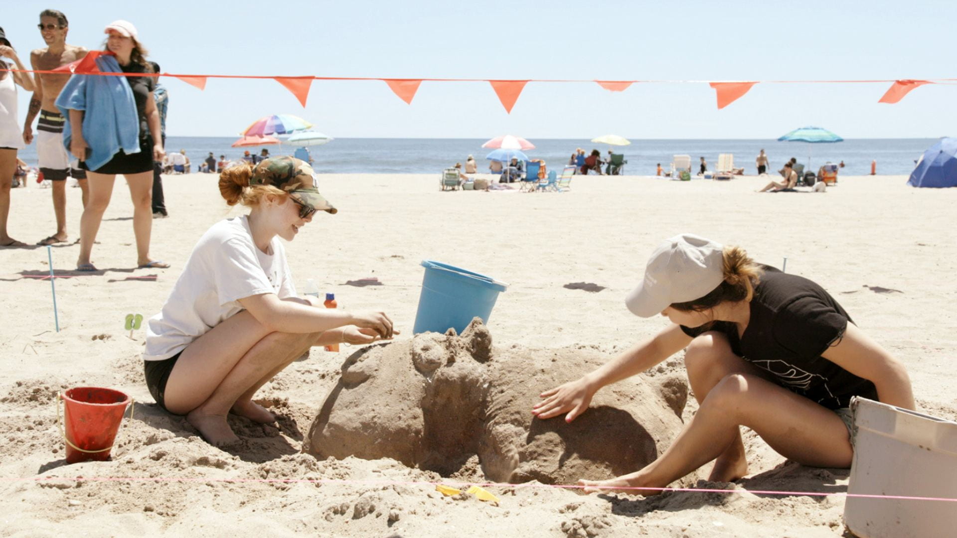 Still on two women on the beach making a sandcastle from The Hottest August