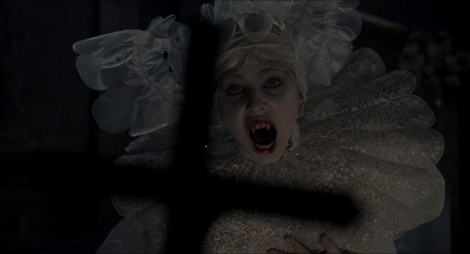 A female vampire screams at a cross