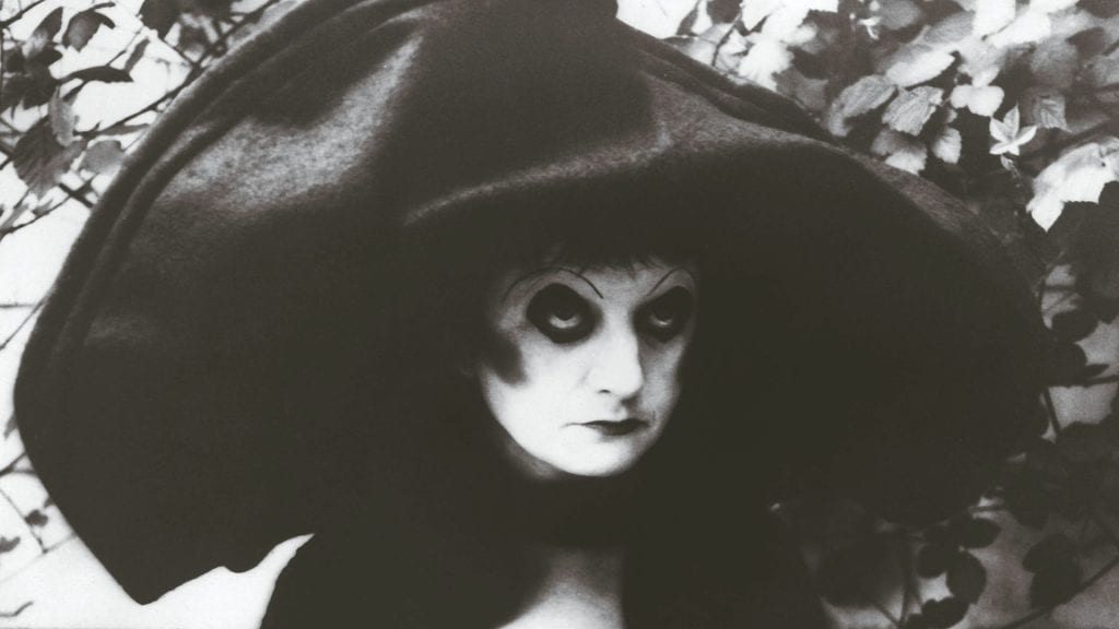 ruth weiss in heavy makeup with a large hat