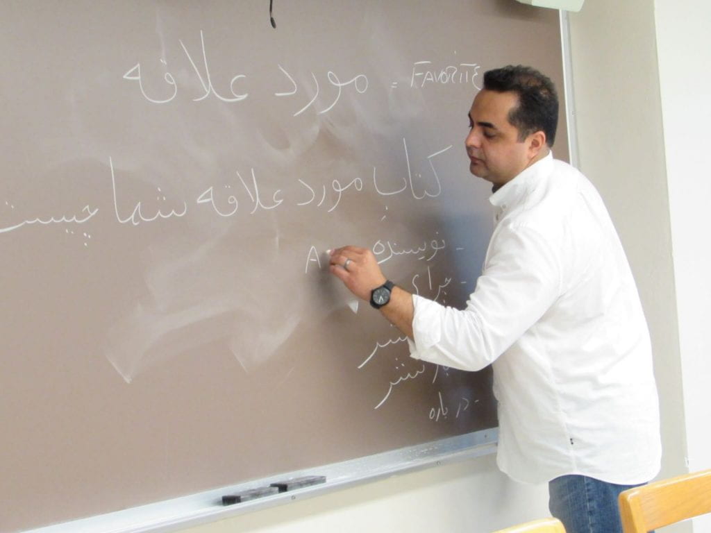 Professor writing on blackboard.