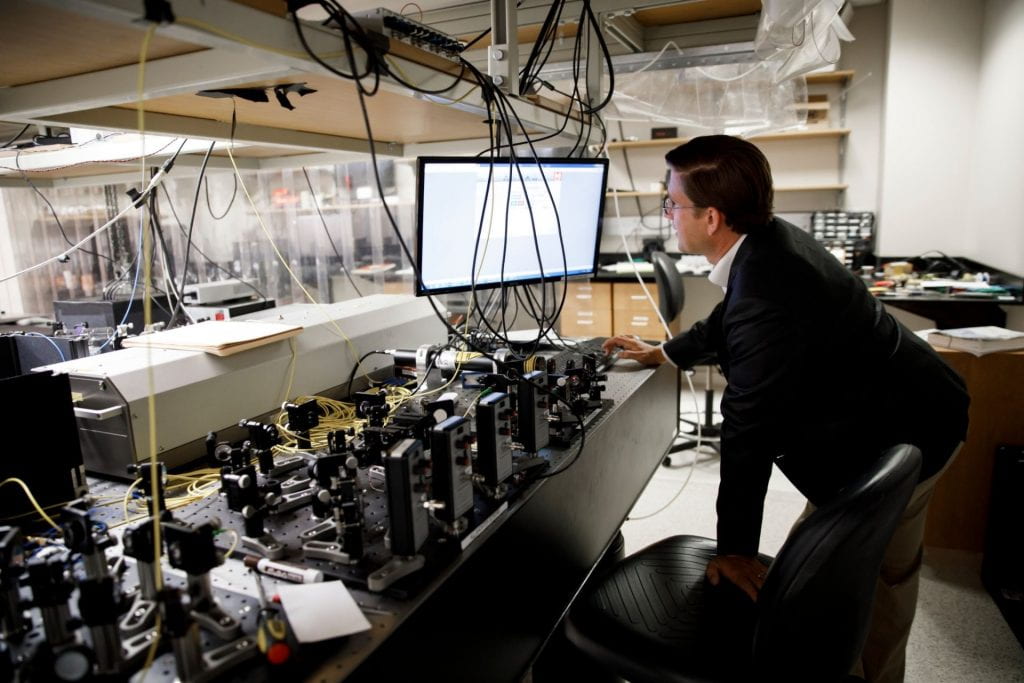 Professor Phil Richerme with laser equipment in lab