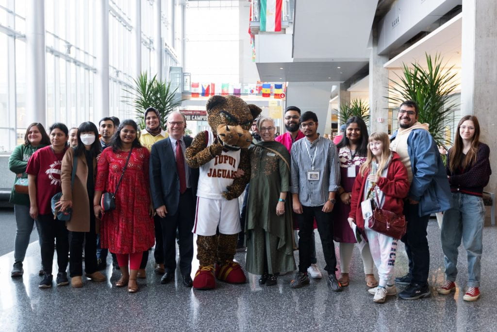 Mascot Jaws poses with Interim Chancellor Klein, Associate Vice Chancellor Kahn, and fesitval participants