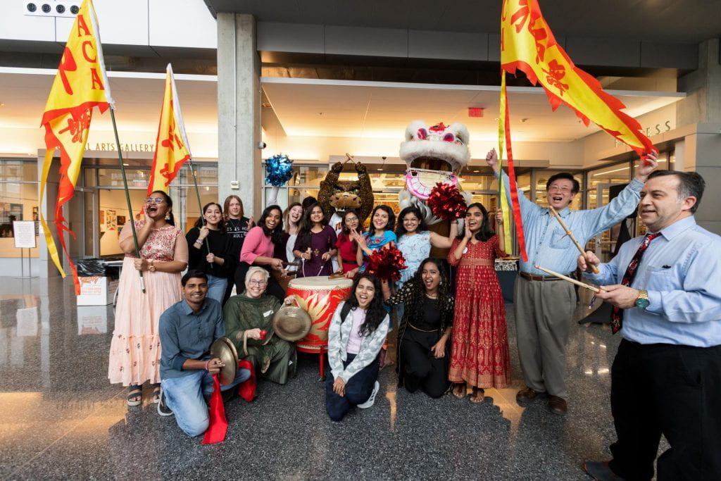 Students and Indiana Association of Chinese Americans Lion dancers pose with drums and flags