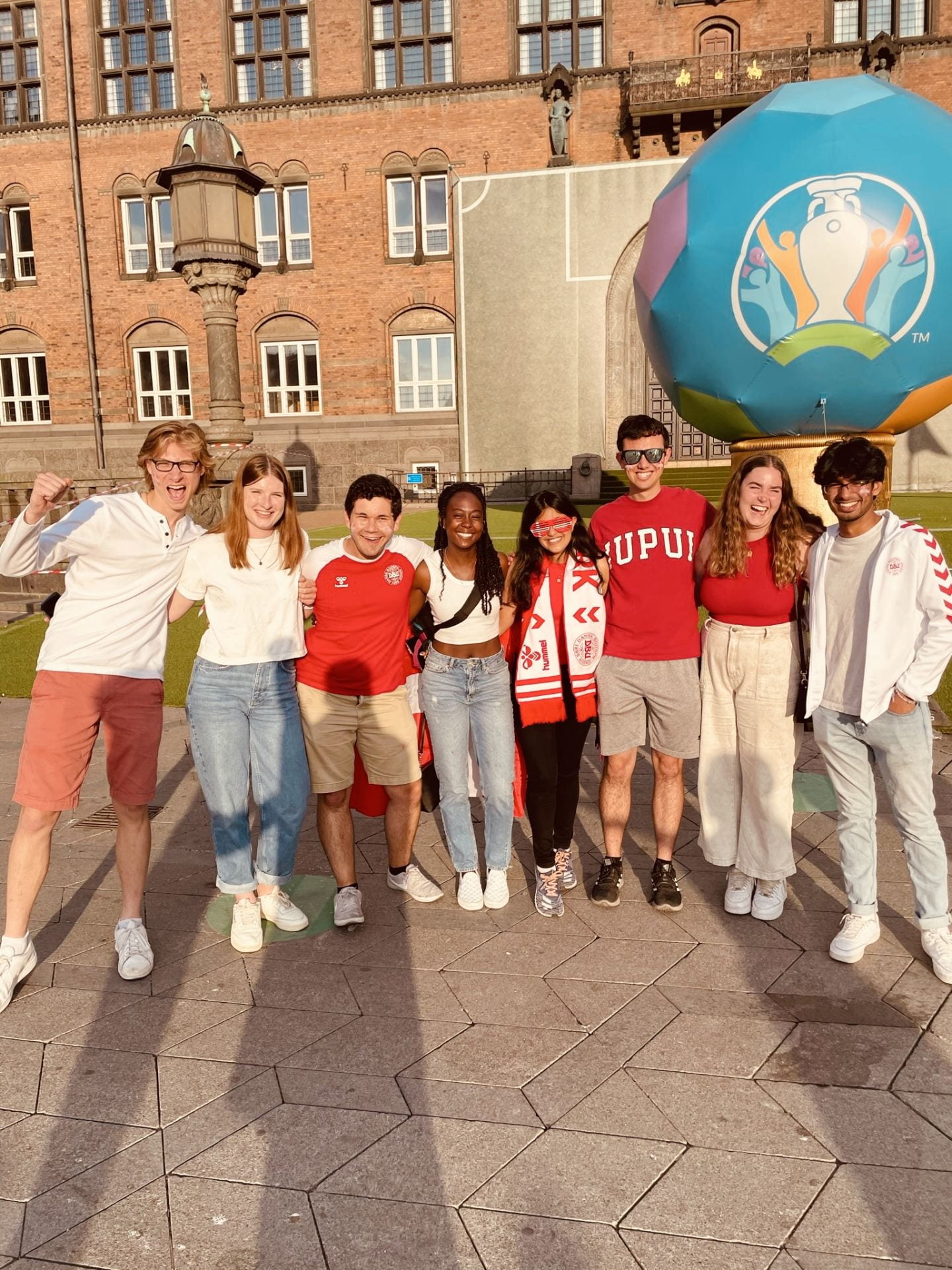 Students studying abroad in Denmark stand in front of the Euro Cup statue