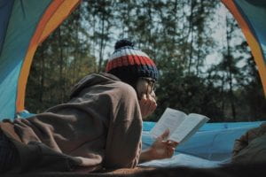 Girl reading in a tent
