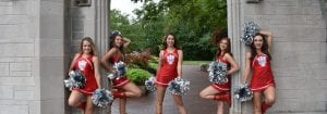 5 dance team members with pom poms and red uniform