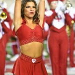 close up of RedStepper in red uniform, arms straight up holding pom poms