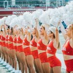 RedSteppers standing in a line with arms straight up, holding pom poms