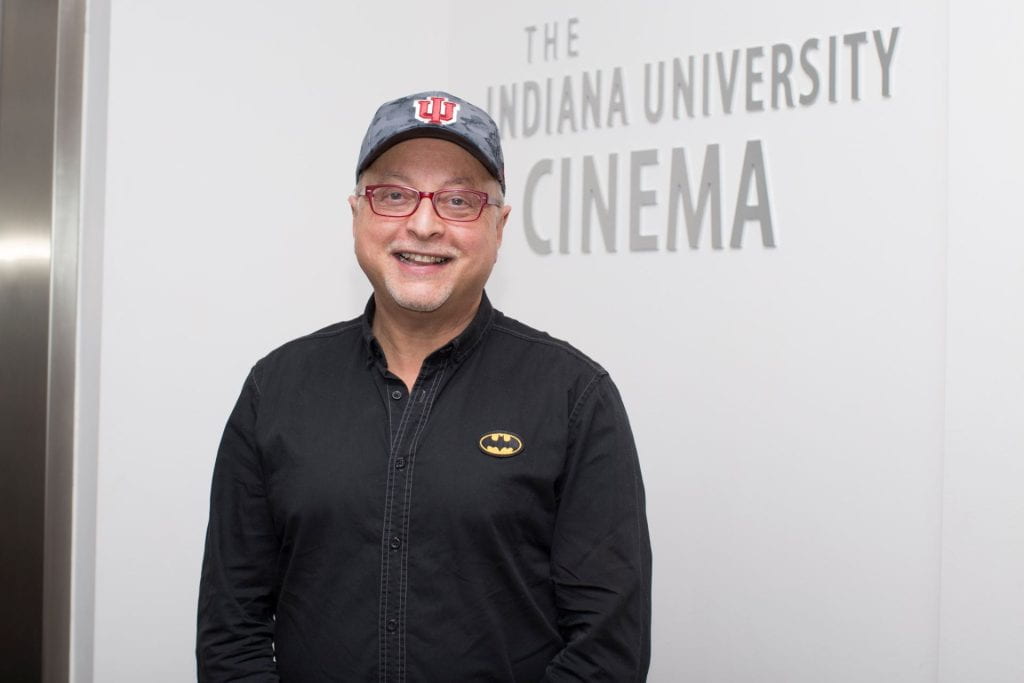 A photograph of Michael Uslan in front of the Indiana University Cinema building.