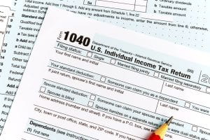 A stock image of a 1040 tax form is displayed on a desk.