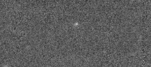 A static-like greyscale background with a small faint white dot only a couple pixels in diameter. 