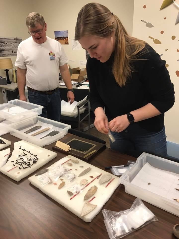 Color photo of archaeologist Molly Mesner identifying and rehousing an archaeological collection at the Glenn A. Black Laboratory of Archaeology.