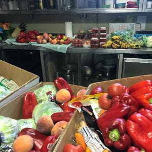 Pictured is one of the grocery deliveries, where fruits and vegetables are sorted into piles before being stored in bins in the walk-in refrigerator. 