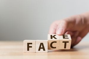 (wooden blocks that spell out the word fact, but show “ke” on the back of “ct” to make it look as though it could also spell fake