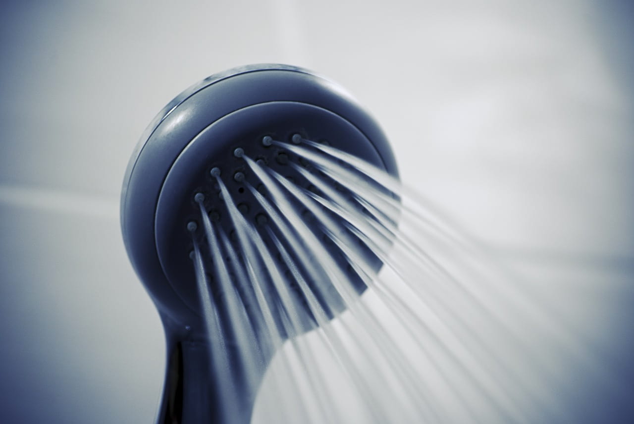 Water coming out of a shower head in a shower.