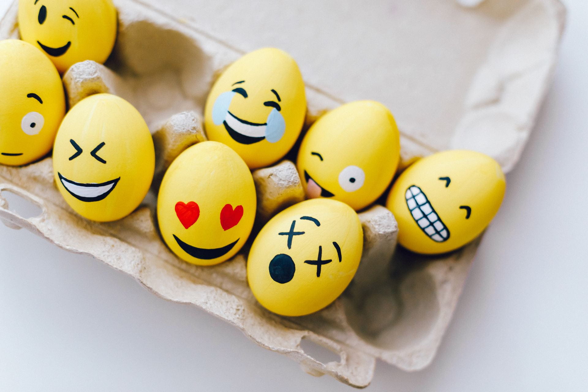 [Yellow painted eggs with various facial expressions.]